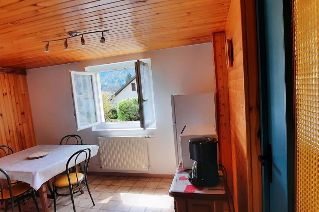 een kleine keuken met een tafel en een koelkast bij plain-pied proche base de loisirs et voie verte in Saulxures-sur-Moselotte