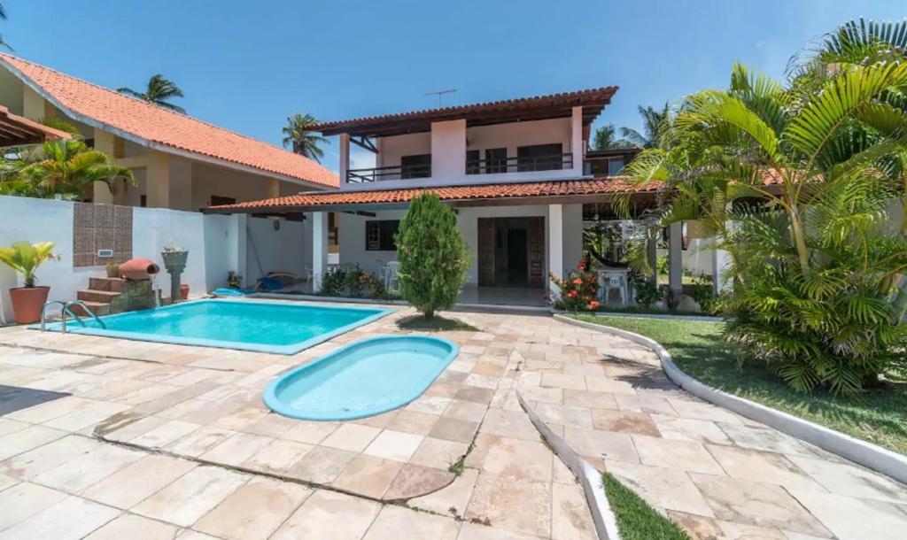 uma villa com piscina em frente a uma casa em Mar e Sol em Porto de Galinhas