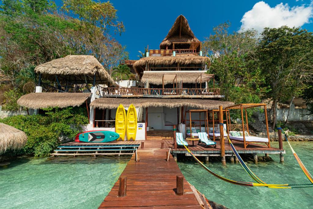 a resort on the water with surfboards on a dock at Xcabal Hotel boutique in Bacalar