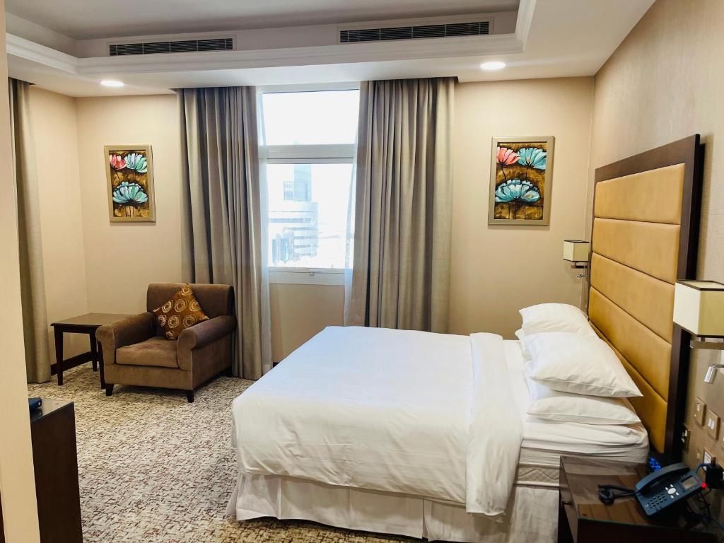una camera d'albergo con letto e sedia di Grand Legacy Hotel Doha a Doha