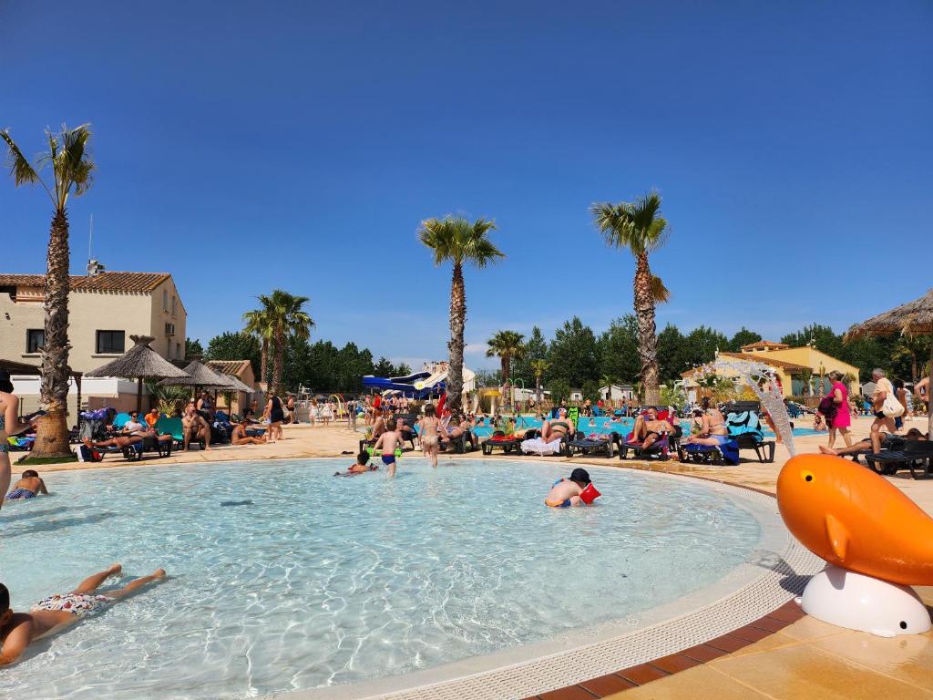 a group of people in a swimming pool at a resort at camping sable du midi 4 etoiles in Valras-Plage