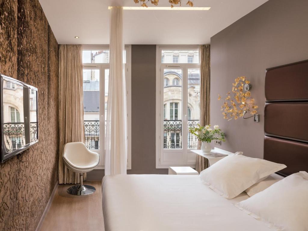 巴黎的住宿－Legend Hôtel Paris，卧室配有白色的床和窗户。