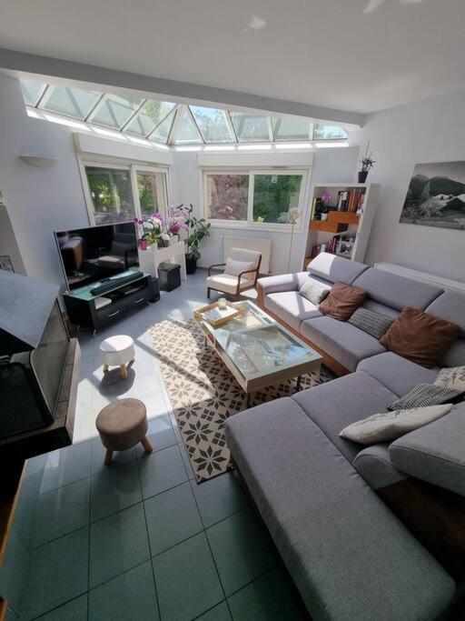 un salon avec un canapé et une télévision dans l'établissement Charmante maison proche de Paris, à Sainte-Geneviève-des-Bois