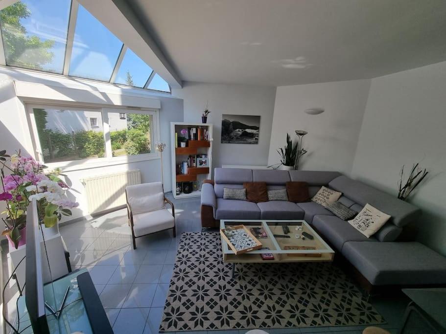 ein Wohnzimmer mit einem Sofa und einem Tisch in der Unterkunft Charmante maison proche de Paris in Sainte-Geneviève-des-Bois