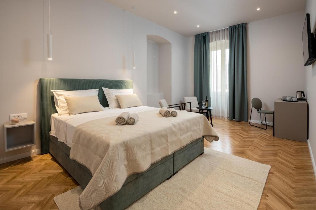 una camera da letto con un grande letto con due asciugamani di Boutique LUX Rooms Odello Split Old Town a Spalato (Split)