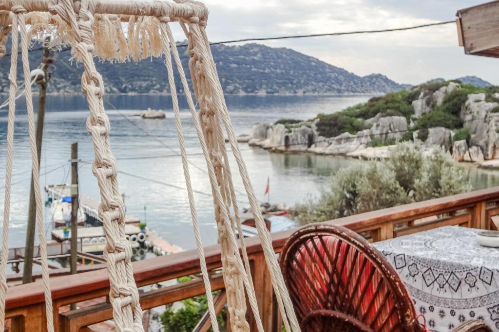 a porch with a table and a view of the water at Naturally Designed Secluded Villa in Kekova in Kaleucagız
