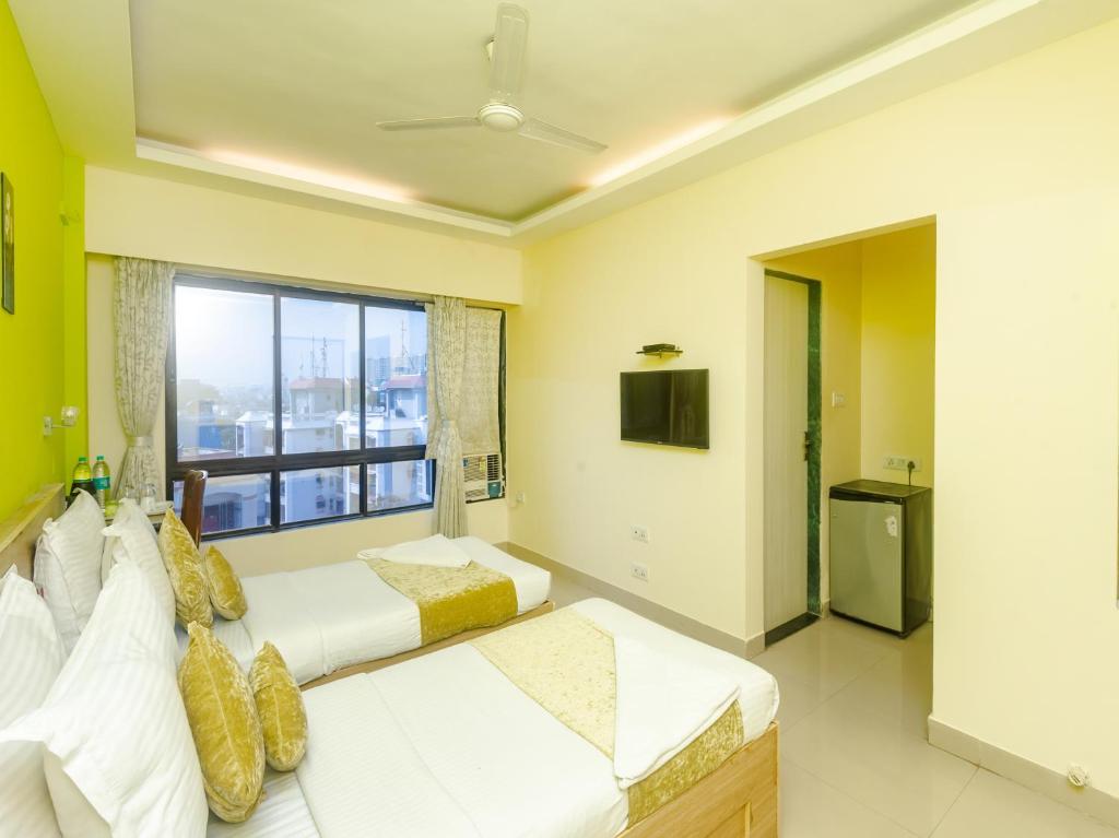 a bedroom with two beds and a window at Hotel Tuliip Residency Mumbai in Mumbai
