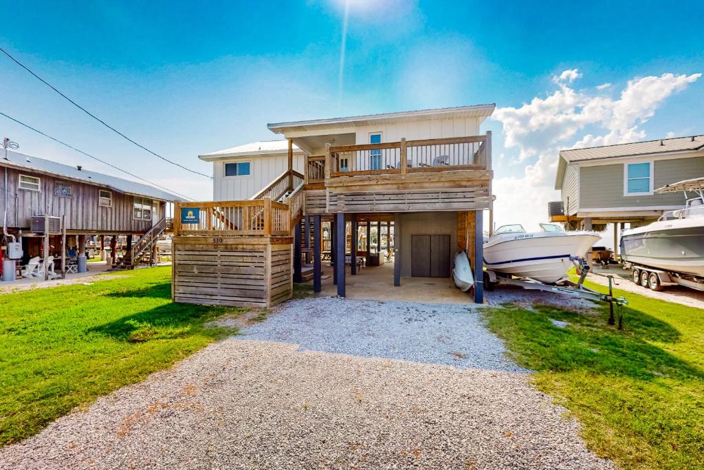 een huis met een boot die ervoor geparkeerd staat bij Sounds Right in Dauphin Island