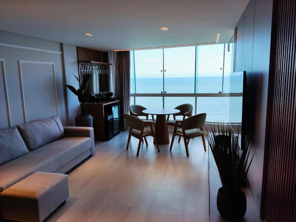 un salon avec un canapé, une table et des chaises dans l'établissement Maravilhoso frente mar, à Balneário Camboriú