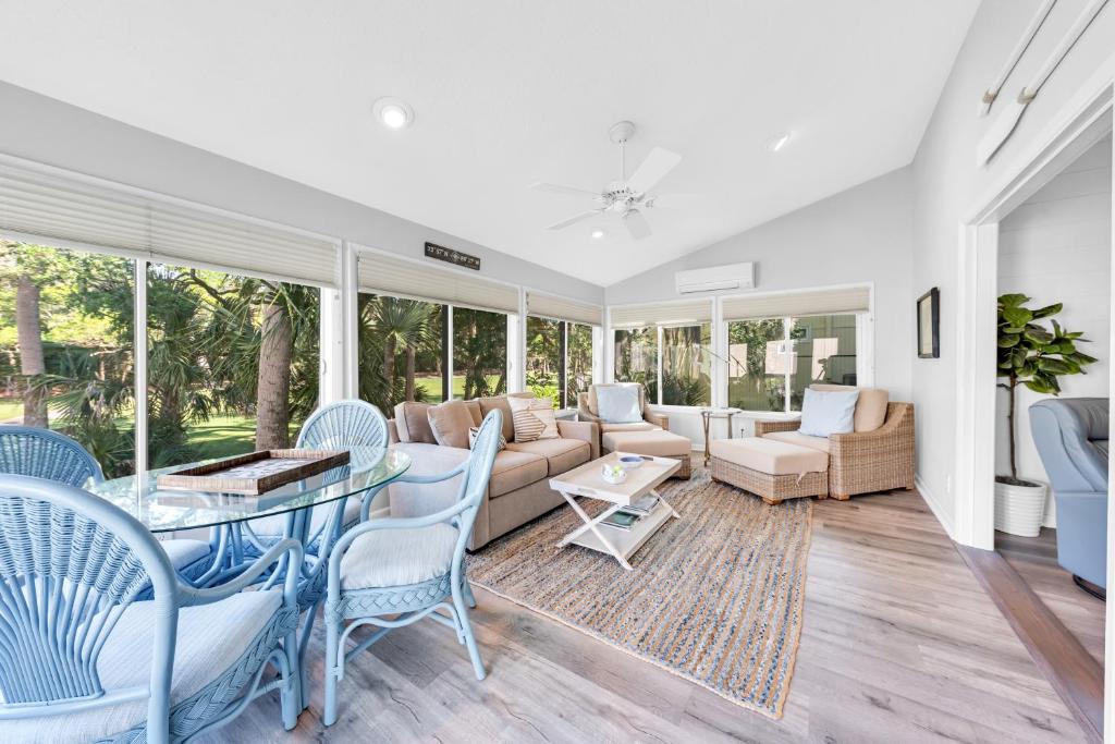 a living room with a glass table and chairs at 507 Tarpon Pond Cottage in Johns Island