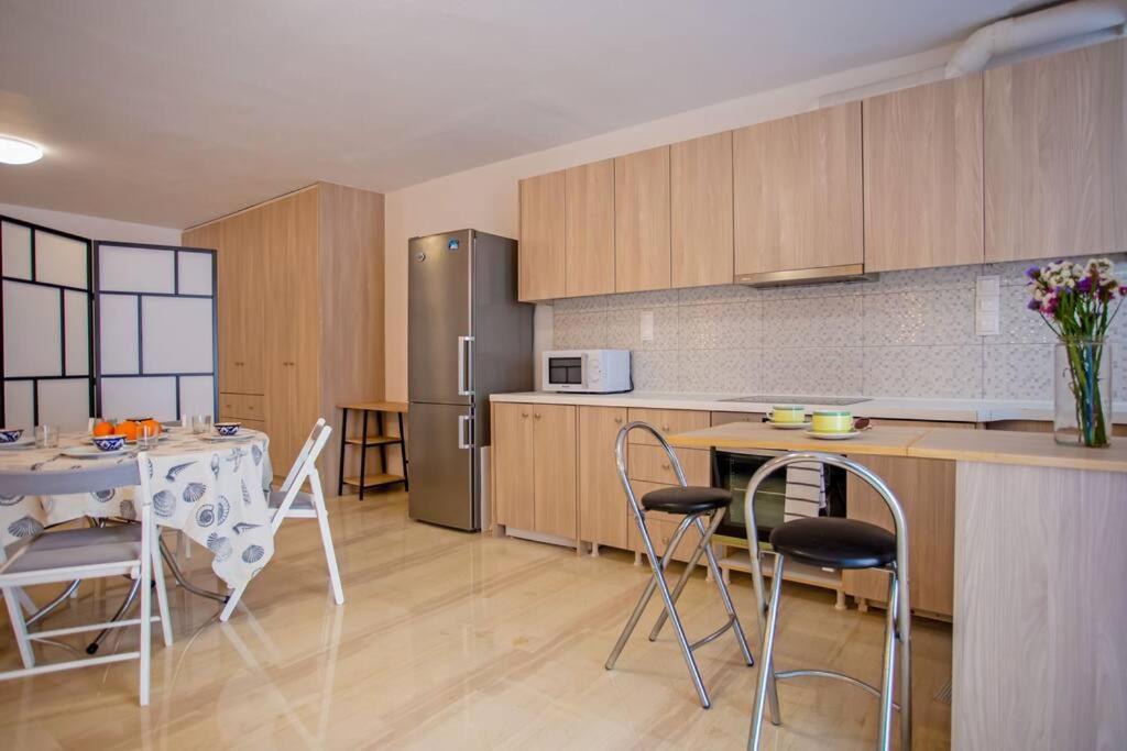 a kitchen with a table and chairs and a refrigerator at Nice & Cosy Mykonos studios in Megali Ammos