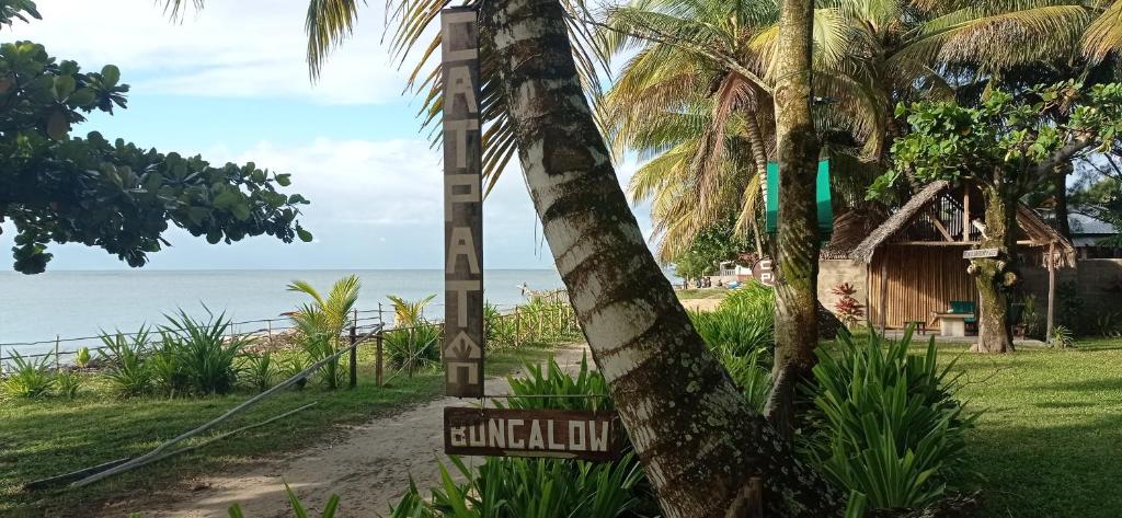 ein Schild an einem Strand neben einer Palme in der Unterkunft cathy patrick (catpat) in Foulpointe