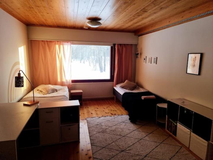 um quarto com duas camas e uma secretária num quarto em Villa Maria em Varkaus