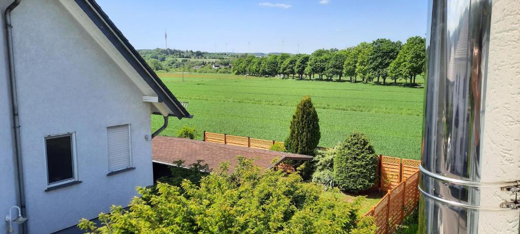a view of a house and a field with trees at Ferienwohnung an der Lahn in Limburg an der Lahn