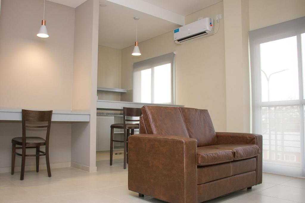 Il comprend un salon avec une chaise brune et une cuisine. dans l'établissement ALOJAMIENTO CENTENARIO, à Corrientes