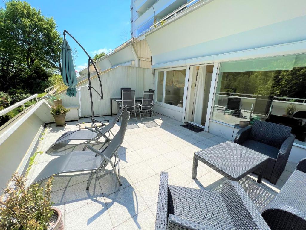 a patio with chairs and tables on a balcony at Panoramic App C02-1 in Sierksdorf