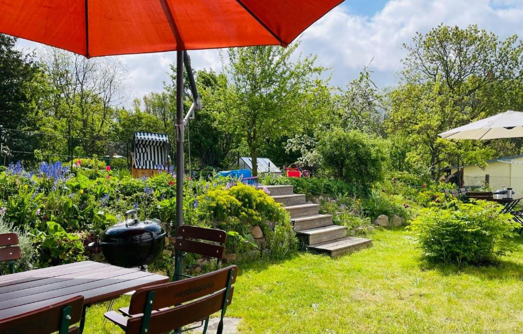 un giardino con tavolo da picnic e ombrellone di Ferienhaus-Fiete-XXL a Sagard