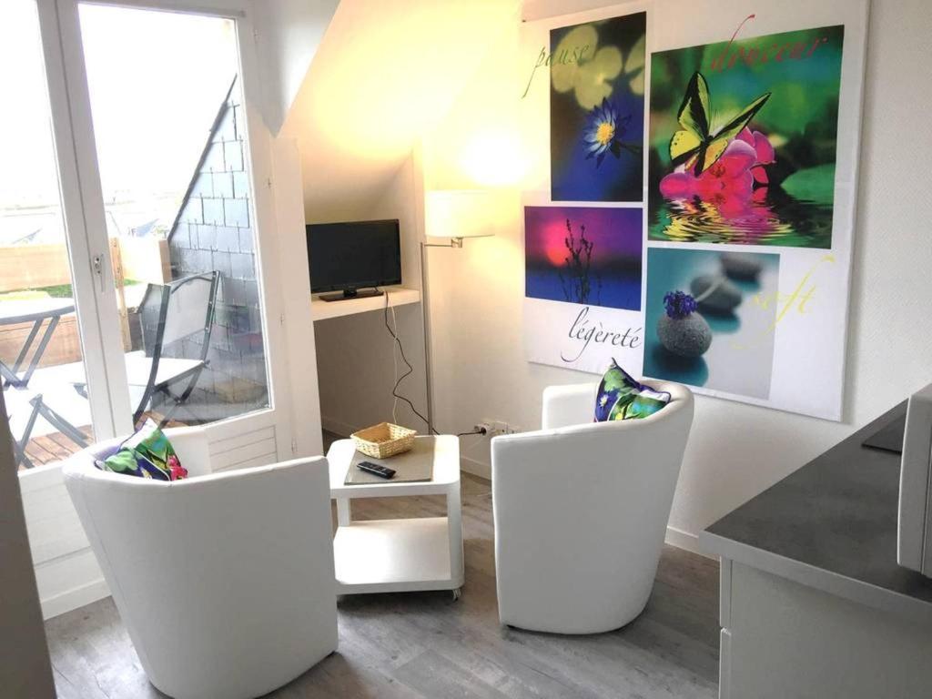 - un salon avec deux chaises blanches et une table dans l'établissement Très joli duplex Port Crouesty Morbihan, à Arzon