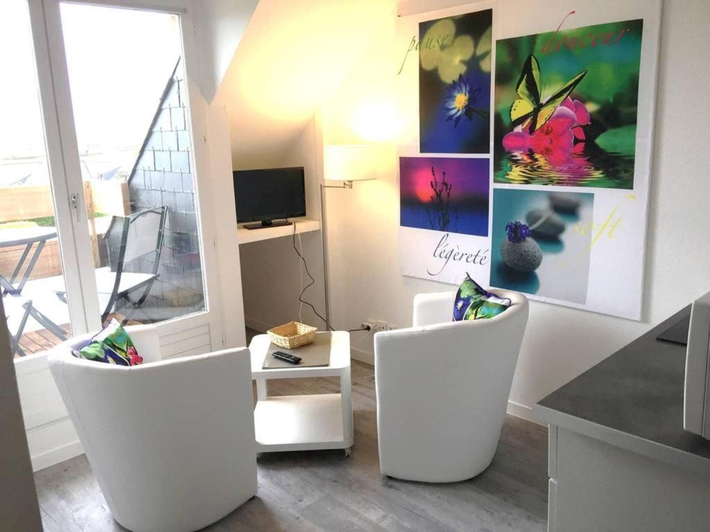 un salon avec deux chaises blanches et une table dans l'établissement Très joli duplex Port Crouesty Morbihan, à Arzon