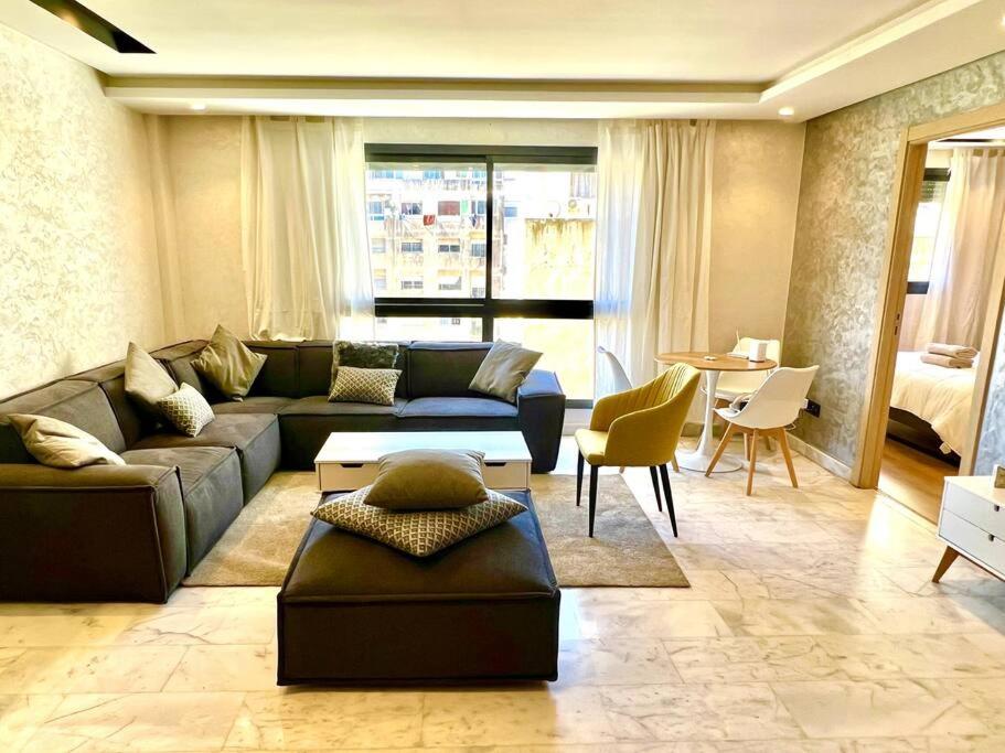 uma sala de estar com um sofá e uma mesa em Best location, 2 minute to beach em Casablanca