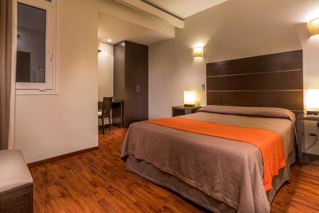 Una cama o camas en una habitación de Gran Hotel Argentino