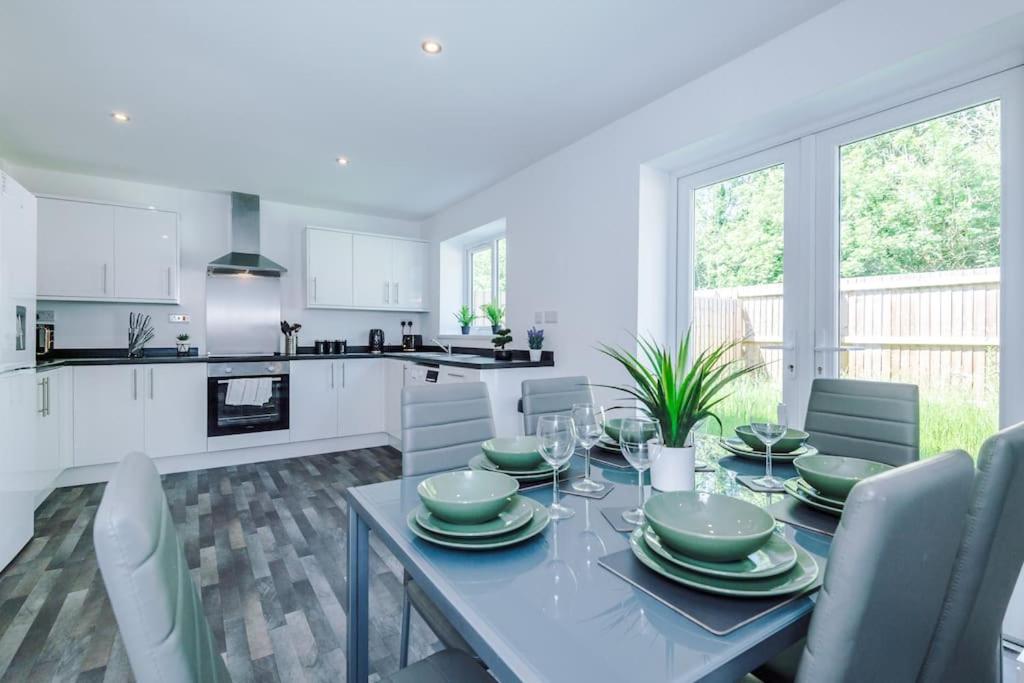 a kitchen and dining room with a table and chairs at Penny Bridge Home From Home in Saint Helens