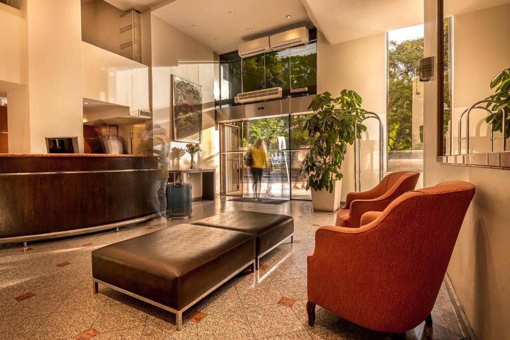 un hall avec un banc et des chaises dans un bâtiment dans l'établissement Gran Hotel Argentino, à Buenos Aires