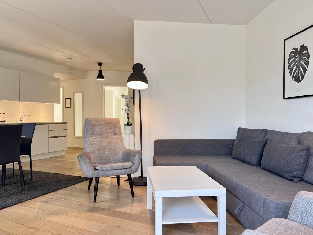 a living room with a couch and a table at Cozy New Apartment In Popular Area 2 in Copenhagen