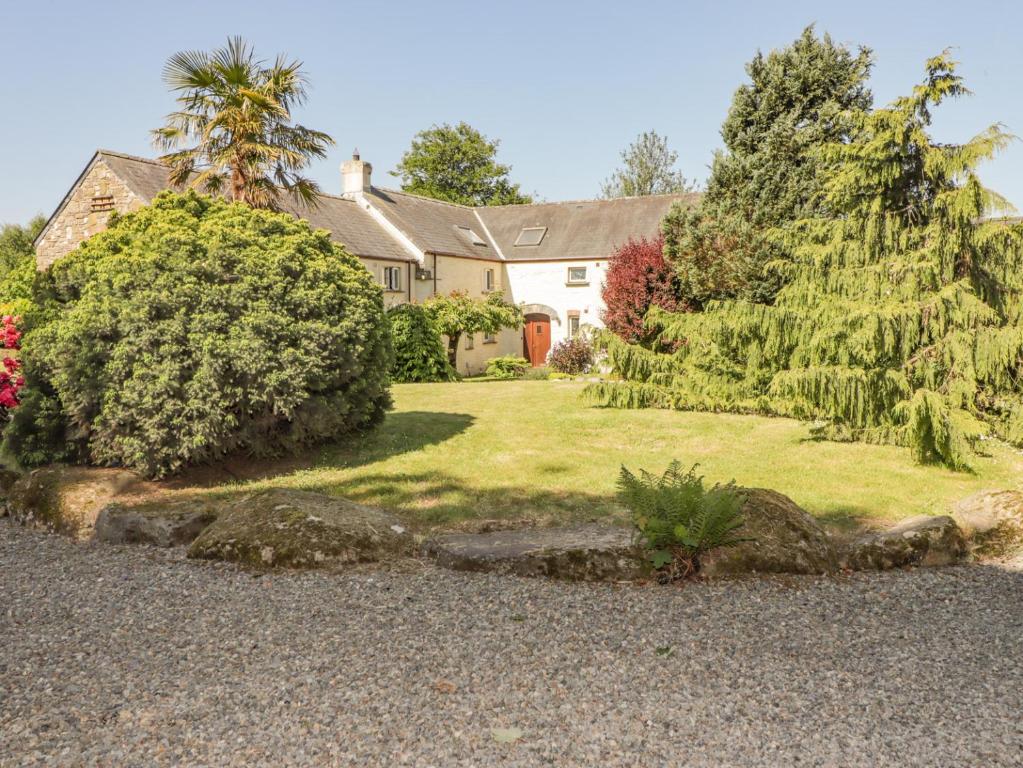 a house with a yard with bushes and trees at 2 Yr Hen Felin in Haverfordwest