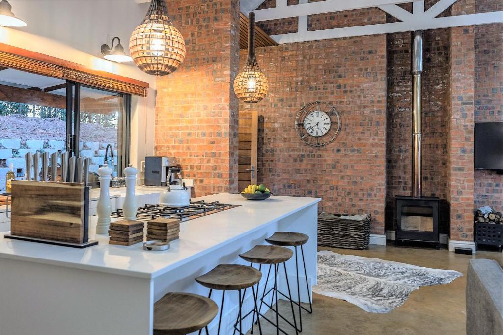 a kitchen with a bar with stools and a stove at Fairfax Cottage in Nottingham Road