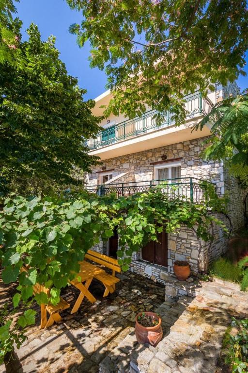 a building with a wooden bench in front of it at Petra Mare Apartments in Alyki