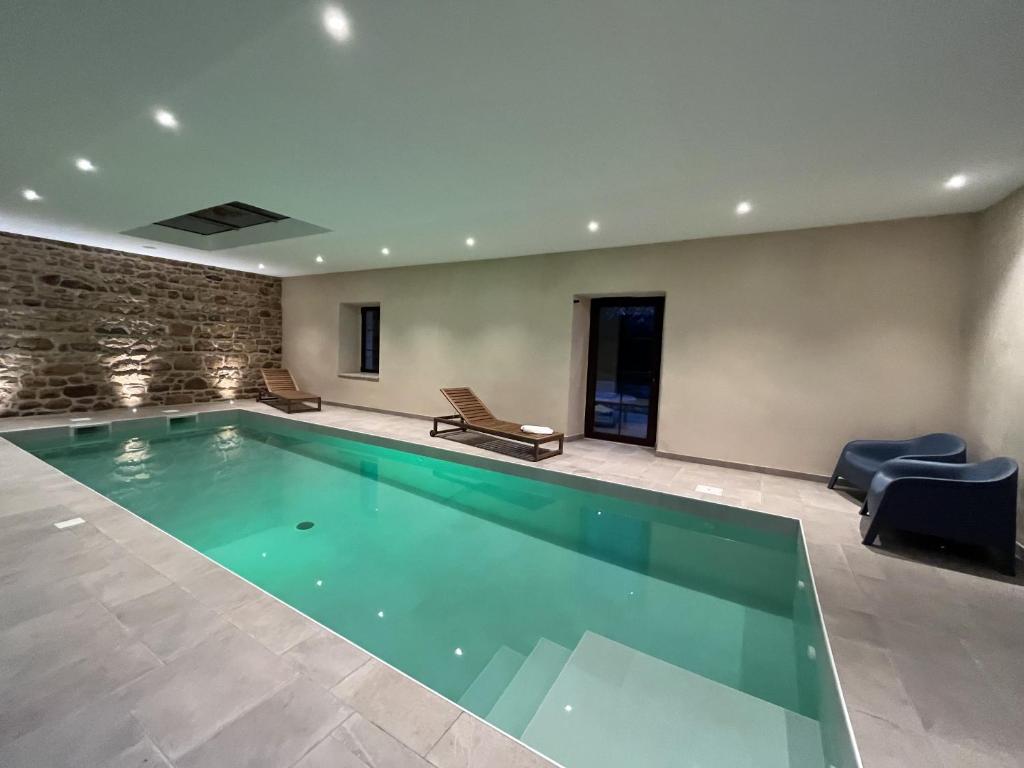 ein großer Pool in einem Gebäude in der Unterkunft Les Villas d Onalou Kergastel in Penvénan
