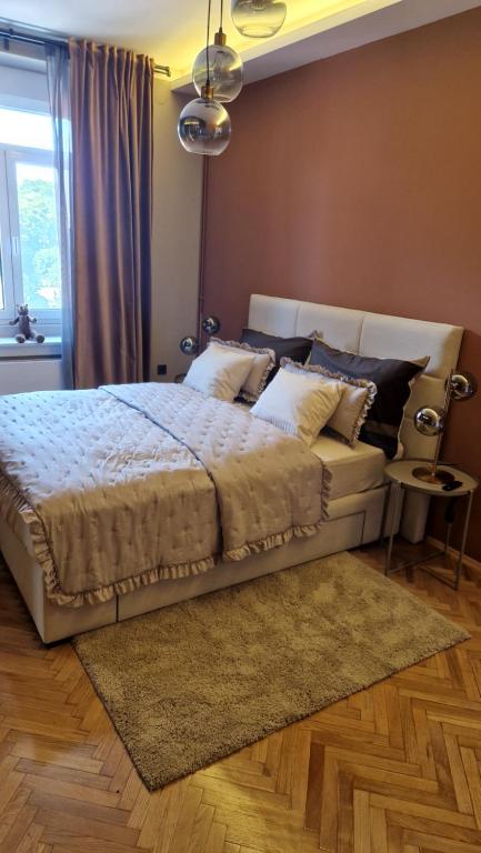 ein Schlafzimmer mit einem großen Bett mit einem Teppich in der Unterkunft Bristol Apartment in the Centre of Zagreb in Zagreb