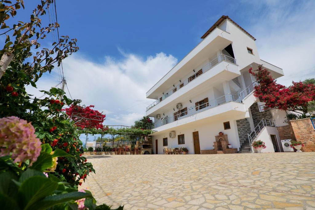 a white building with flowers in front of it at Vila Genci in Ksamil