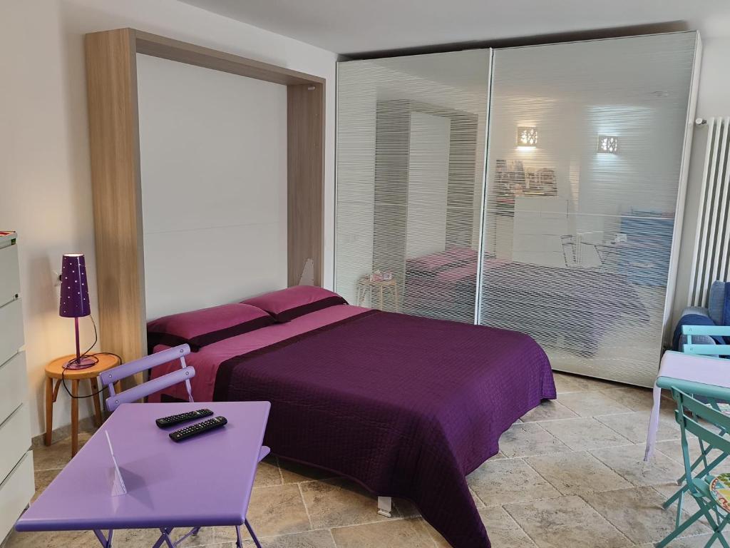 um quarto com uma cama roxa e uma grande janela em Villa Alberto em Olbia
