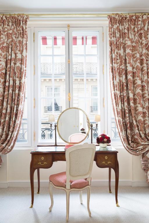 a desk with a mirror and a chair in front of a window at Le Bristol Paris - an Oetker Collection Hotel in Paris