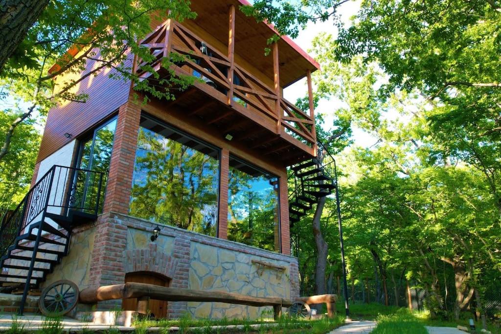 a tree house with a balcony on top of it at Villa Vejini cabin in Mamkoda
