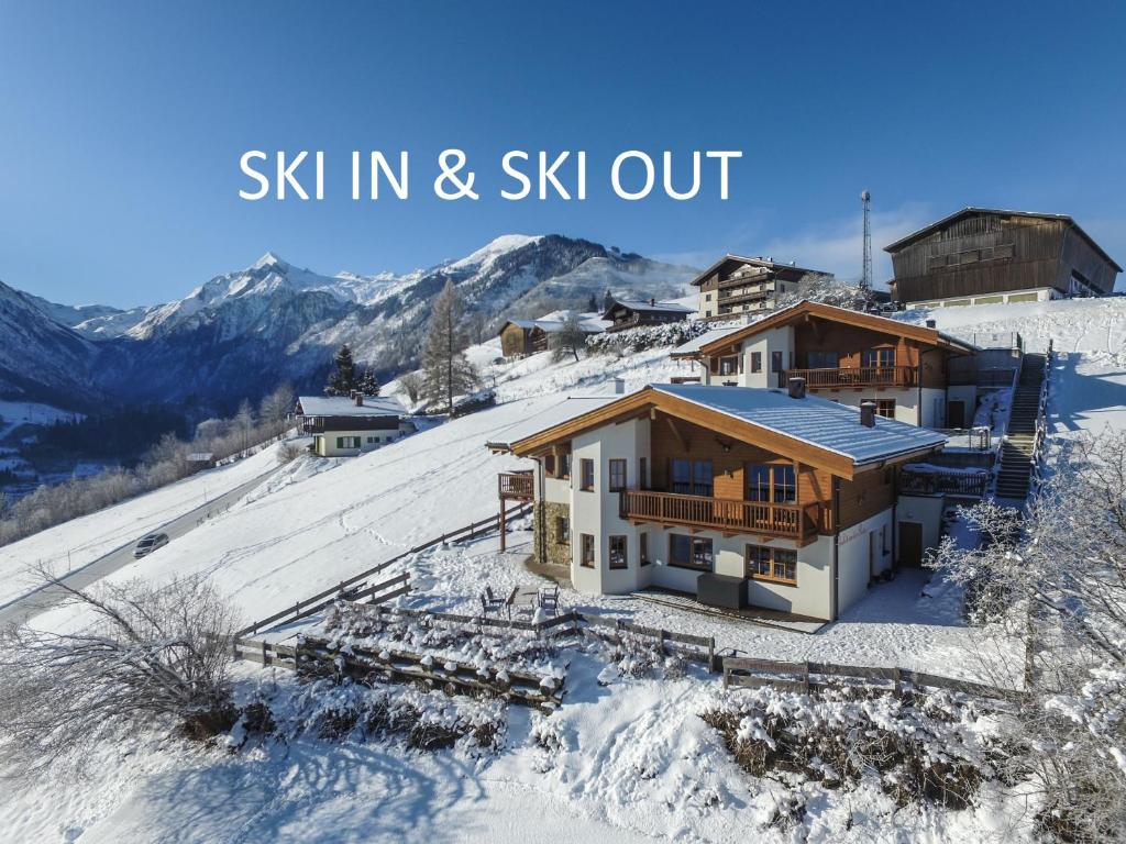 a house in the snow with the words ski in and ski out at Chalet an der Piste in Kaprun