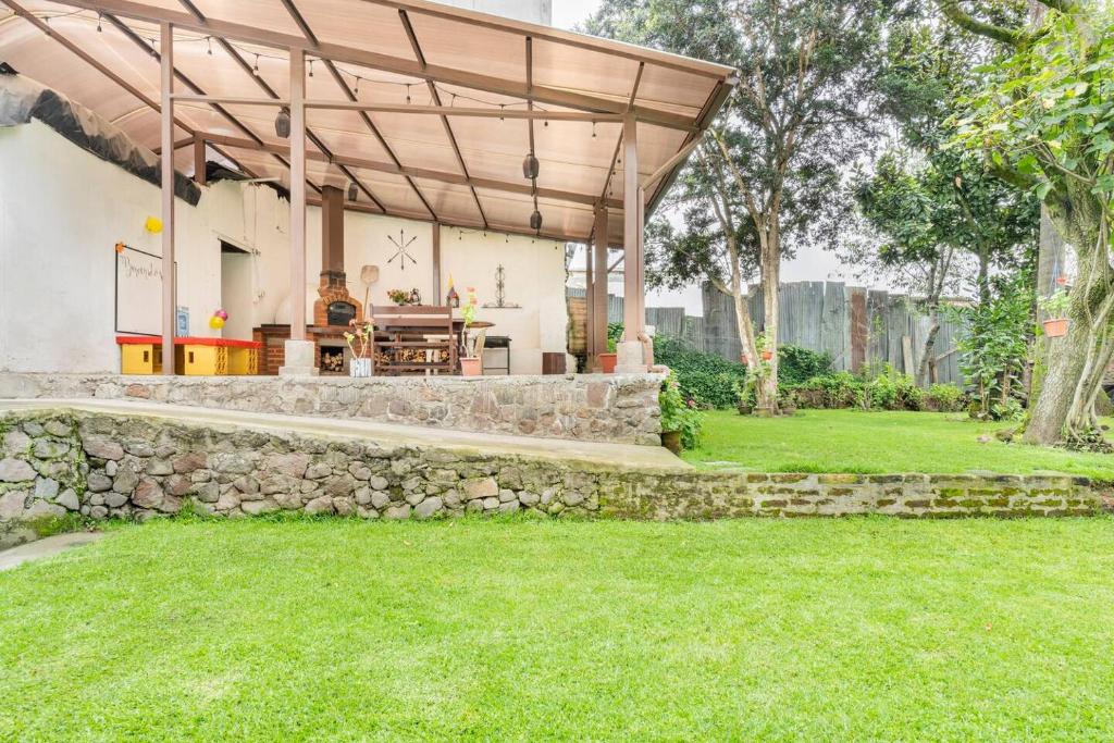 una casa con una pared de piedra y una pérgola de madera en TRAVELER'S HOUSE QUITO, en Quito