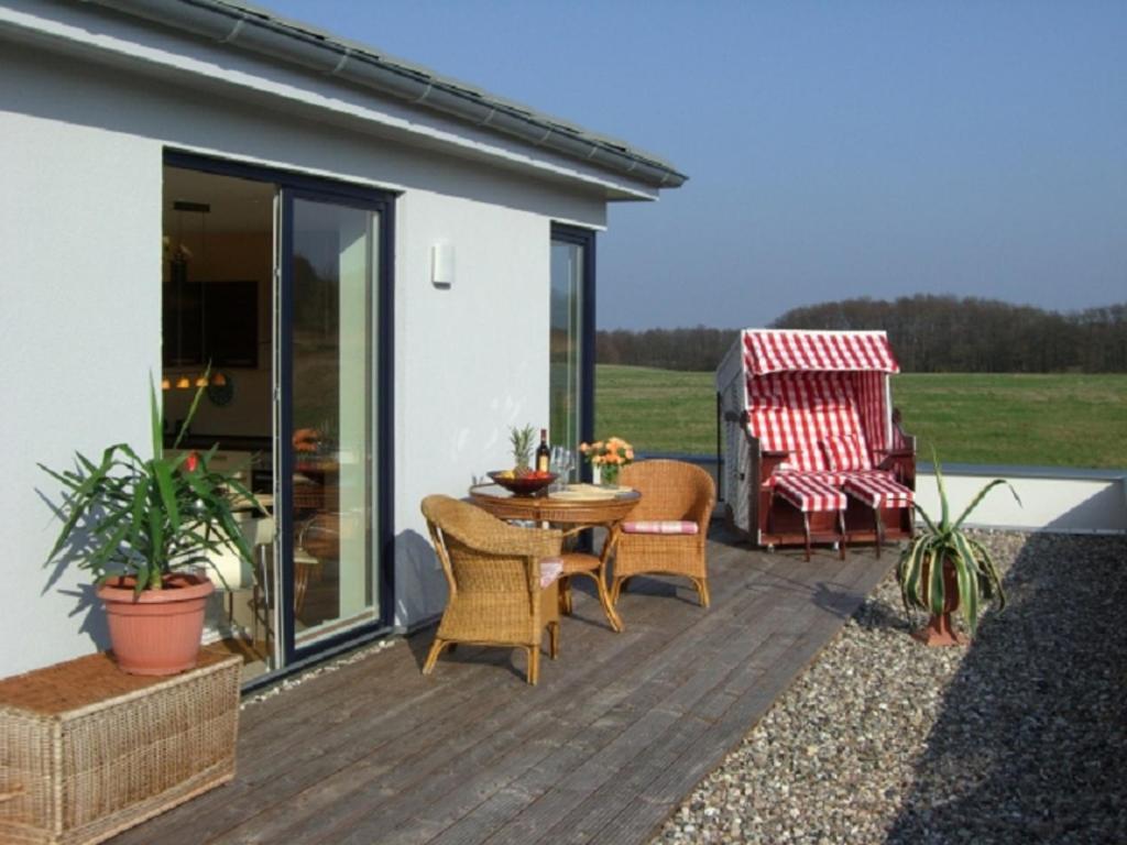 a patio with a table and chairs on a deck at Villa im Grünen excl Privatsphäre in Wittenbeck