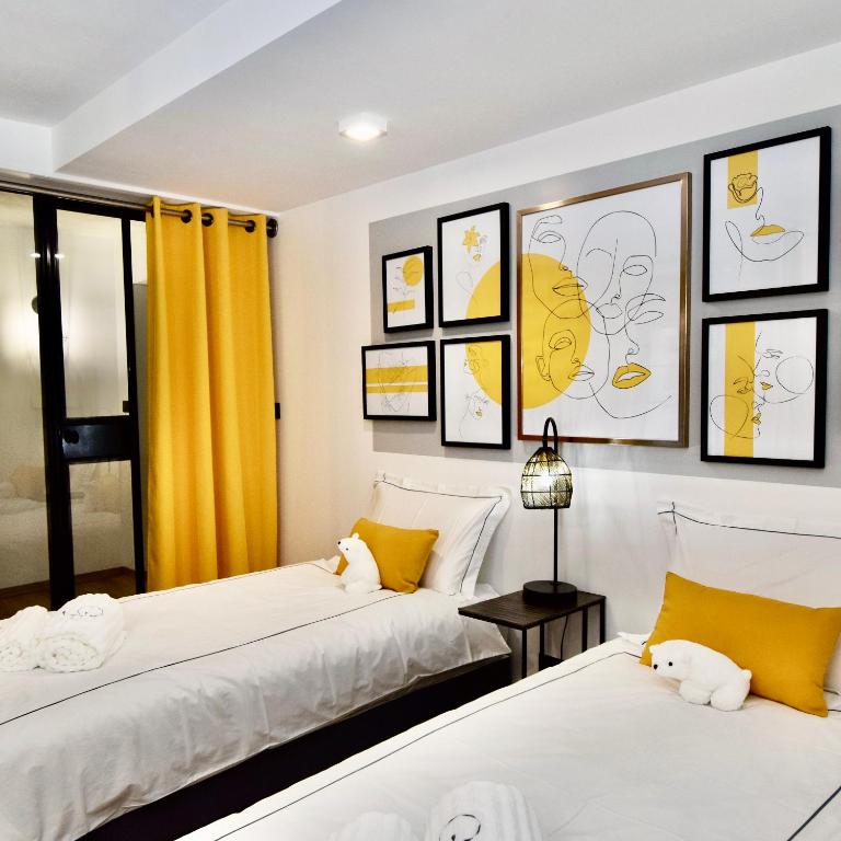 2 Betten in einem Zimmer mit Bildern an der Wand in der Unterkunft Grande Plage in Saint-Georges-de-Didonne