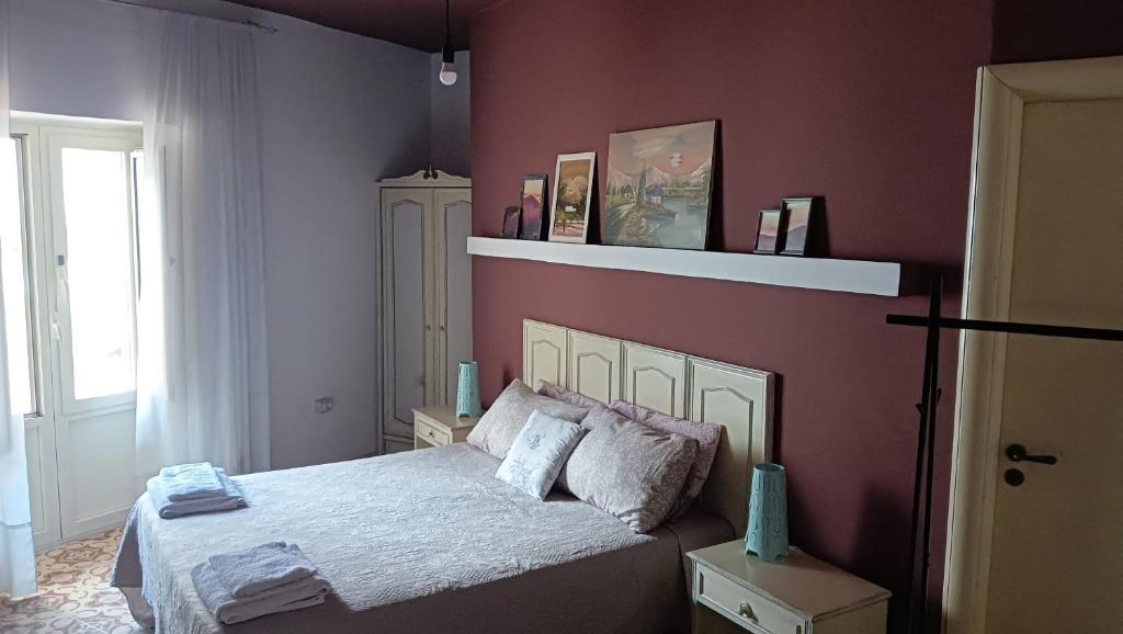 una camera con un letto con una parete rossa di La Sbecciatrice a Villa Santa Croce