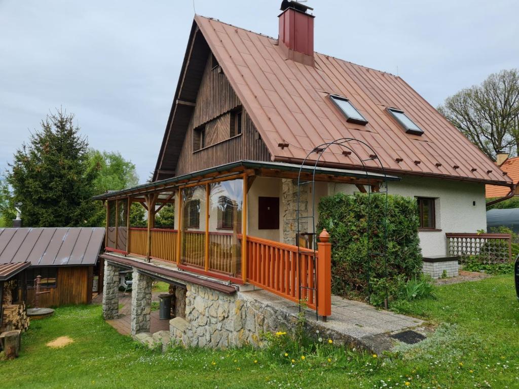 une maison avec une terrasse couverte et un toit dans l'établissement Chalupa Zvičina, 