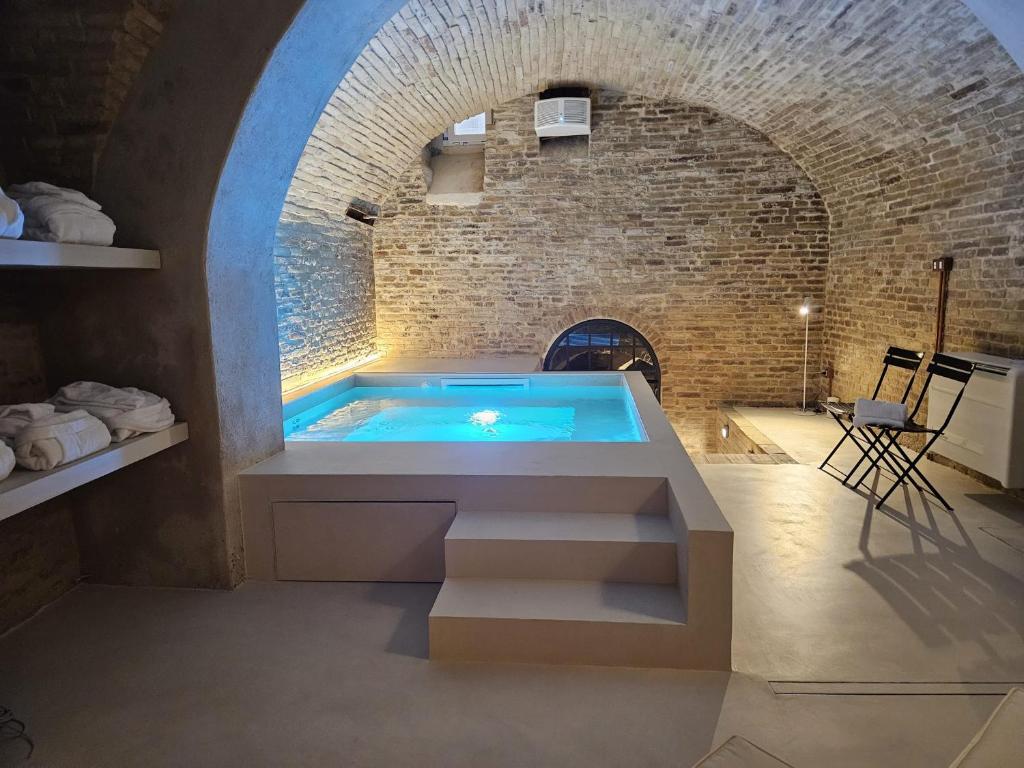 Habitación con paredes de ladrillo y bañera de hidromasaje. en Piccola Dimora Gherardini, en SantʼElpidio a Mare