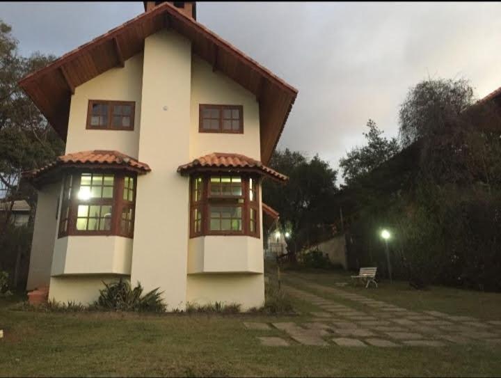 uma pequena casa com um telhado em cima em Chalés Bela Vista em Monte Verde