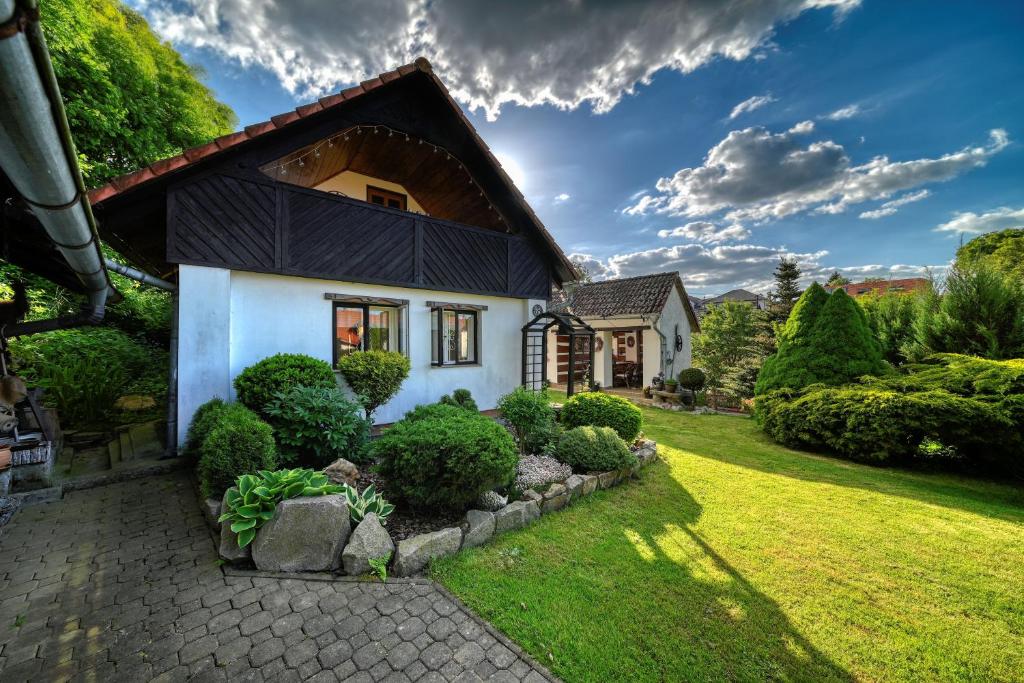 una casa con techo negro y patio verde en Chaloupka u potoka, en Kutná Hora