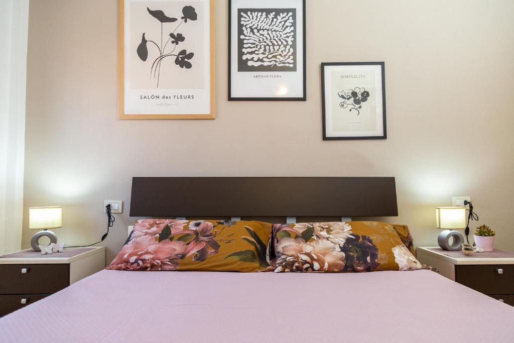 a bedroom with a bed and three pictures on the wall at La casa di NONNO ELIGIO in Bari Sardo
