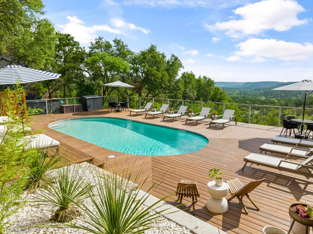 a swimming pool on a wooden deck with lounge chairs at The Bygone in Wimberley