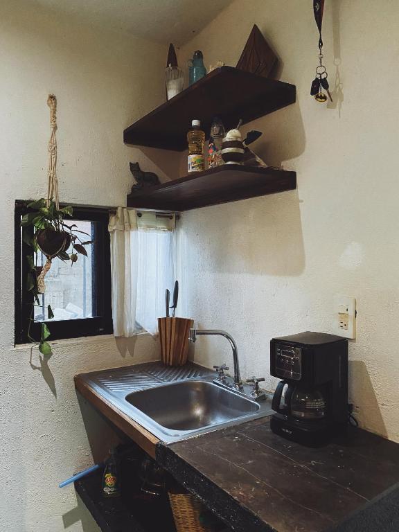 a kitchen with a sink and a microwave at La Punta surfhouse in Puerto Escondido
