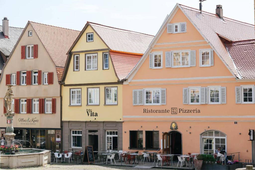 una fila de edificios en una calle con mesas en Hotel Schiller, en Bietigheim-Bissingen